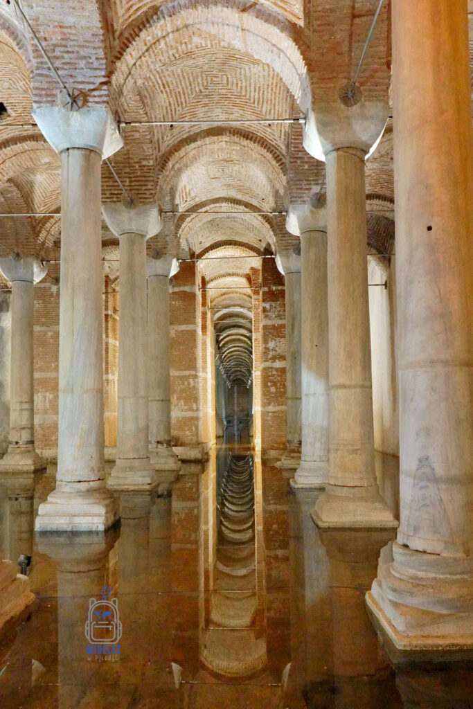 Wnętrze starożytnej Cysterny Justyniana w Stambule z rzędami marmurowych kolumn odbijających się w wodzie, tworzące tajemniczą atmosferę. Jedna z najważniejszych atrakcji turystycznych dzielnicy Sultanahmet, idealna na zwiedzanie z przewodnikiem