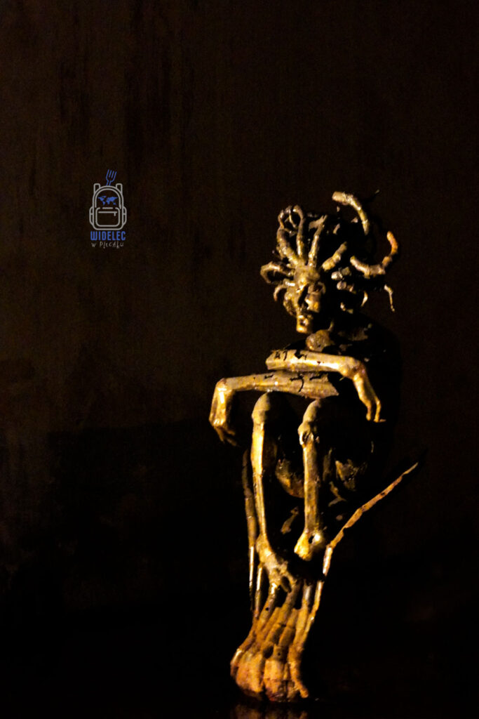 Artystyczna rzeźba przedstawiająca Meduzę z wężowymi włosami, podświetlona w ciemnym, tajemniczym otoczeniu, eksponowana w Cysternach Justyniana w Stambule