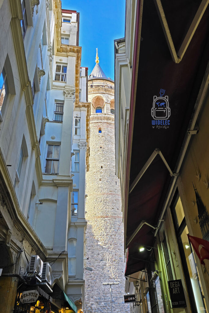 Wieża Galata w Stambule widziana z wąskiej uliczki otoczonej zabytkowymi kamienicami – jeden z symboli tureckiej architektury i historii.