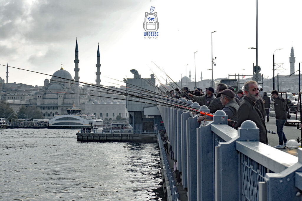  Most Galata w Stambule – wędkarze łowiący ryby na tle meczetu Yeni Cami i malowniczej panoramy miasta.