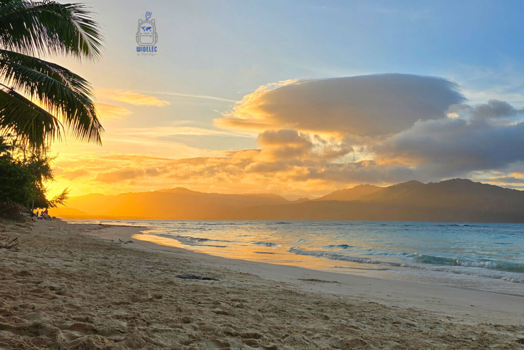 Malowniczy zachód słońca na plaży w Dominikanie, gdzie złote promienie słońca oświetlają gładką powierzchnię oceanu i zarys gór w oddali. Ciepłe światło rozświetla palmy wzdłuż wybrzeża, dodając scenerii egzotycznego uroku. To doskonałe miejsce na spokojny wieczór, gdzie każdy moment staje się niezapomniany. Idealny widok dla tych, którzy pragną poczuć urok Karaibów
#widelecwpleacaku
#dominikana - z wschodu na zachód - z południa na północ