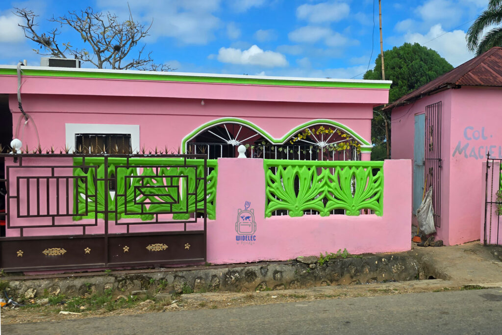Kolorowy kreolski domek w Ameryce Łacińskiej – różowa fasada z zielonymi zdobieniami i metalowym ogrodzeniem. Charakterystyczna architektura i żywe barwy odzwierciedlają lokalny styl budownictwa. Egzotyczne miasteczka pełne takich domków to kwintesencja podróży poza utartym szlakiem. #WidelecwPlecaku
#Dominikana – Z wschodu na zachód - z południa na północ
