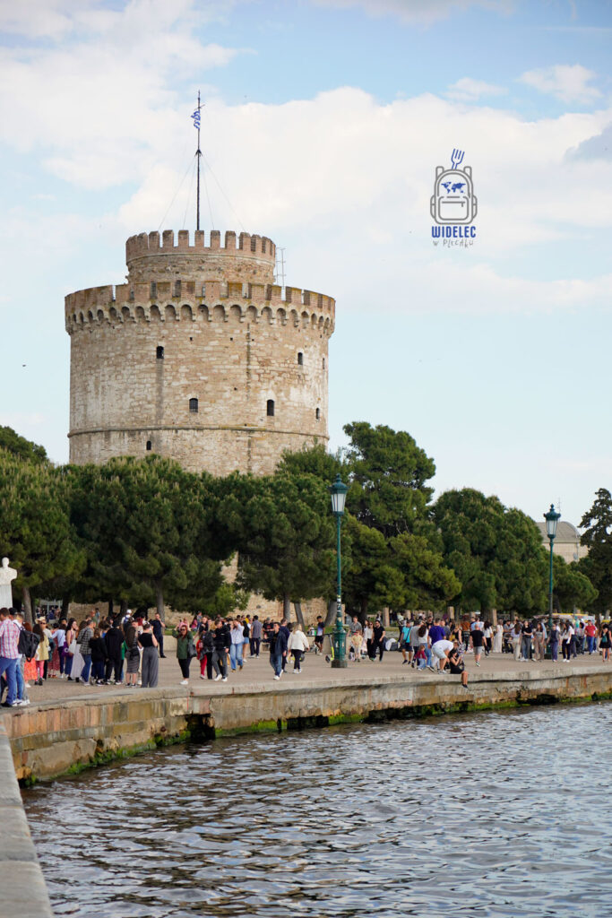 Biała Wieża w Salonikach, tłum spacerujących ludzi nad nabrzeżem Morza Egejskiego