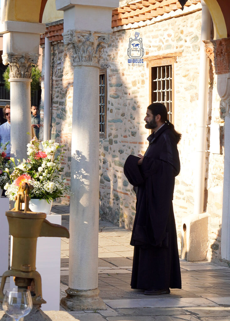 Mnich prawosławny na dziedzińcu cerkwi w Salonikach – moment skupienia w greckim słońcu, wpisujący się w codzienne życie miasta. Saloniki – Bogowie, Galeriusz i Gyros.