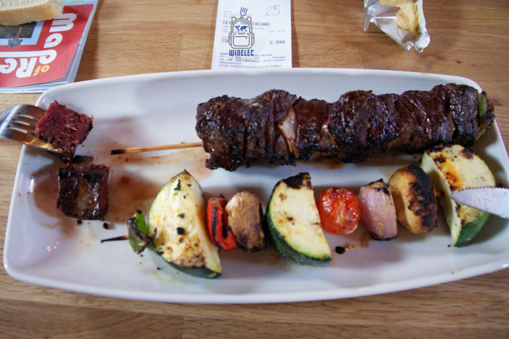 Islandia – płetwal karłowaty (Milky whale) podany jako szaszłyk z warzywami na talerzu, kontrowersyjny smak Islandii, widelecwplecaku.pl