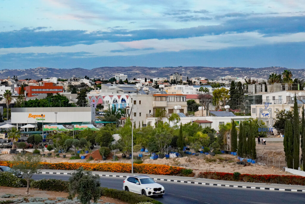 Cypr – wyspa dobrej pogody i dobrego humoru – panorama współczesnego Pafos z zabudową mieszkalną, zielenią i wzgórzami w tle, codzienne życie miasta na zachodnim Cyprze, podróże i kultura wyspy – widelecwplecaku.pl