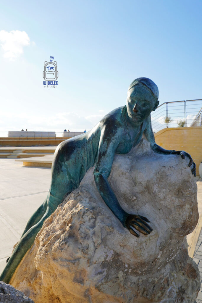 Cypr – wyspa dobrej pogody i dobrego humoru – współczesna rzeźba nadmorska w Pafos przedstawiająca postać na kamieniu, sztuka publiczna nad Morzem Śródziemnym i spokojna atmosfera miasta – widelecwplecaku.pl