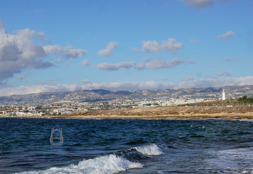 Widok na Pafos od strony morza – zachodni Cypr, linia brzegowa miasta, zabudowa Pafos i latarnia morska w tle, jedno z najważniejszych historycznych miast Cypru – widelecwplecaku.pl