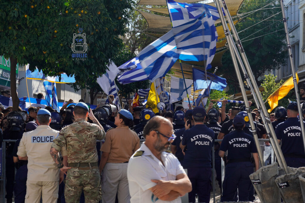 Nikozja – kordon policji i greckie flagi podczas demonstracji w podzielonej stolicy Cypru, napięcia polityczne i granica między częścią grecką i turecką, Cypr – wyspa kontrastów, widelecwplecaku.pl