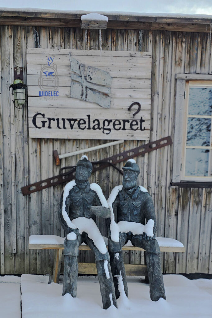 Rzeźba dwóch górników przed historycznym budynkiem w Longyearbyen na Svalbardzie.