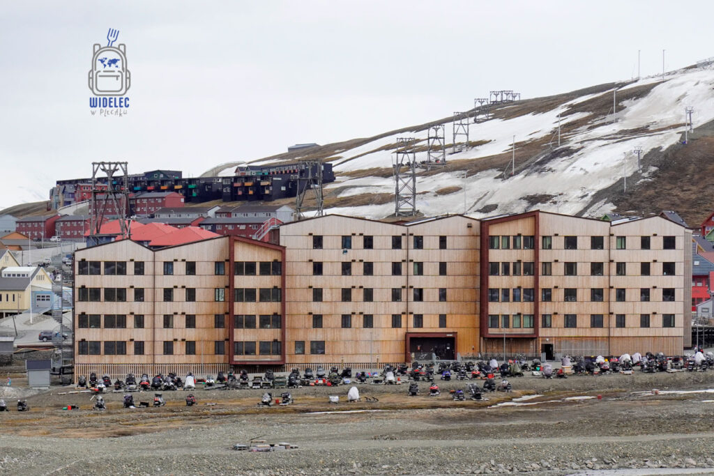 Parking pełen skuterów śnieżnych przed hotelem w Longyearbyen na archipelagu Svalbard.