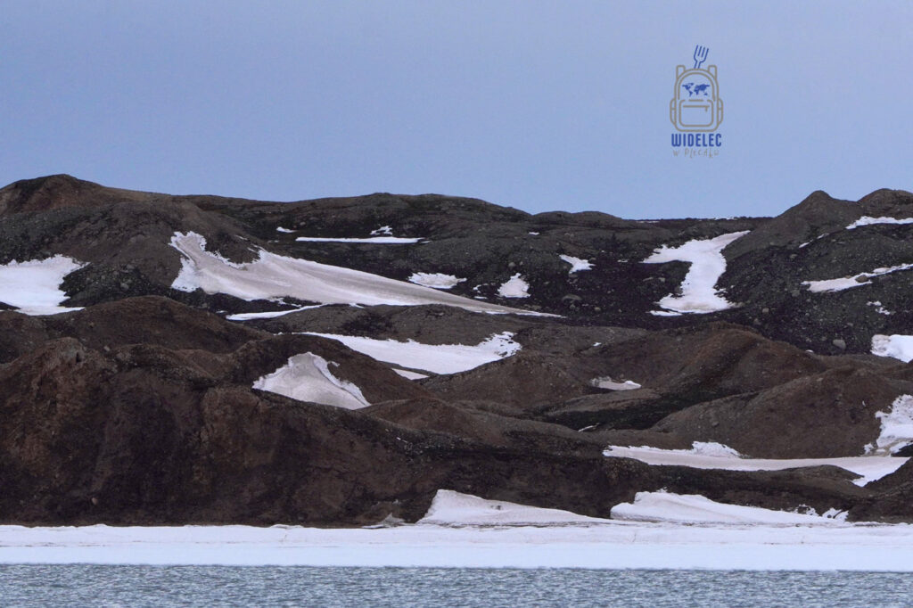 ciemnobrązowe szczyty pod niebieskim niebem, z lekko przy śnieżone. Svalbard, Arktyka