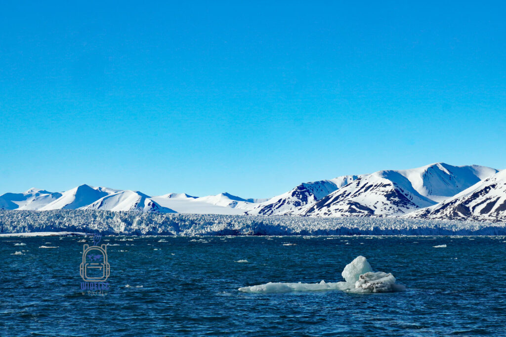 samotna kra dryfująca po morzu grenlandzkim w tle lodowiec i wzgórza, Svalbard, Arktyka